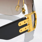Dior sunglasses close-up of gold hinge on black frame with tinted lens edge