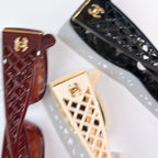 Chanel sunglasses close-up, lattice temple pattern on burgundy and cream frames