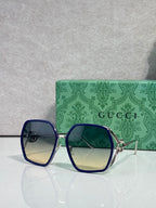 Sunglasses with cobalt blue square frames and blue tinted lenses, gold-tone arms