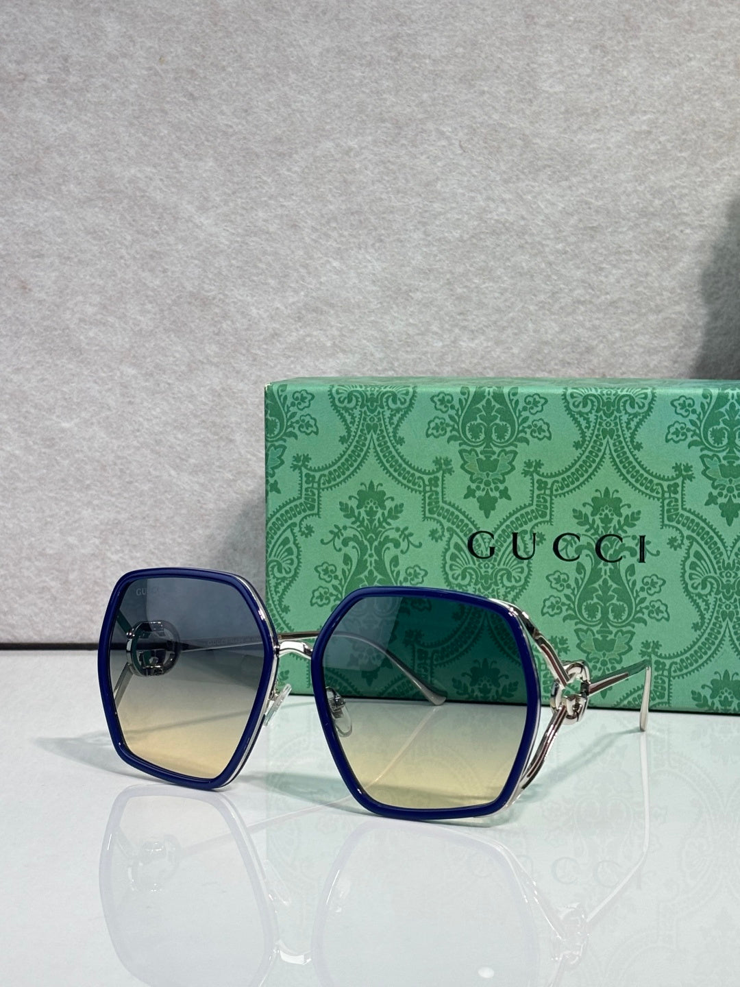 Sunglasses with cobalt blue square frames and blue tinted lenses, gold-tone arms