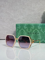 Sunglasses with rose-pink square frames and mauve tinted lenses, gold-tone accents