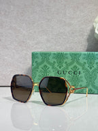 Sunglasses with dark maroon square frames and blue tinted lenses, gold-tone accents