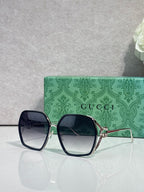 Sunglasses with dark navy square frames, smoky blue lenses, and gold-tone hardware