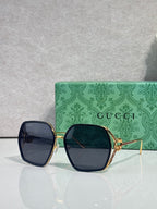 Sunglasses with dark navy square frames, blue lenses, and gold-tone metal hinges