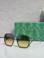 Sunglasses with dark navy square frames and blue gradient lenses, gold-tone details