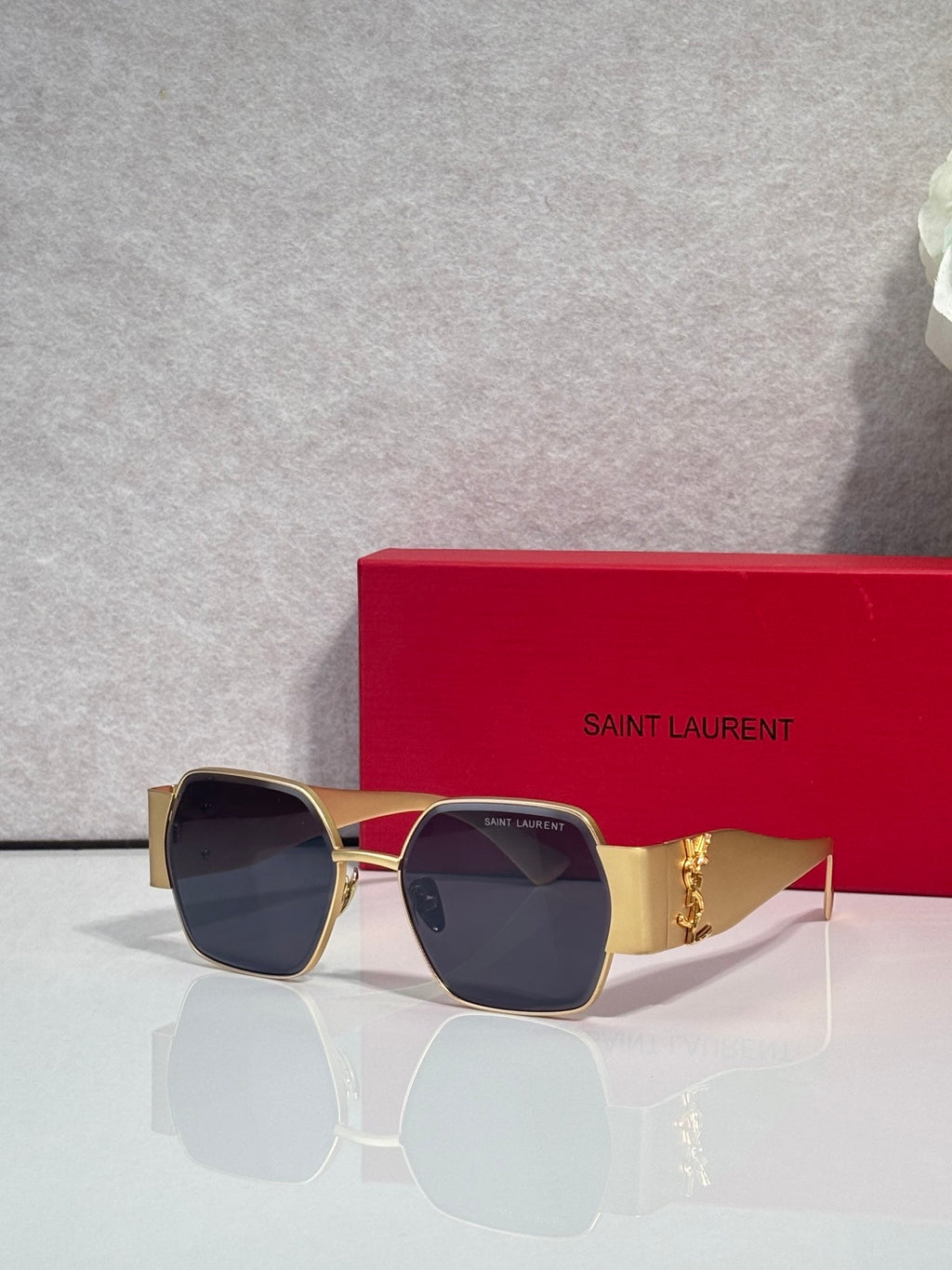 Square sunglasses with tinted lenses, dark frame, gold-tone temples