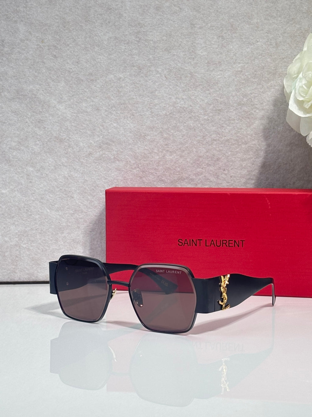 Square sunglasses with dark tinted lenses, navy frame, gold-tone arms