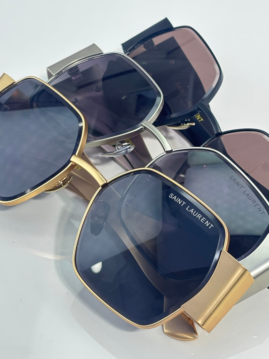 Stacked square sunglasses with tinted lenses, gold and navy frames