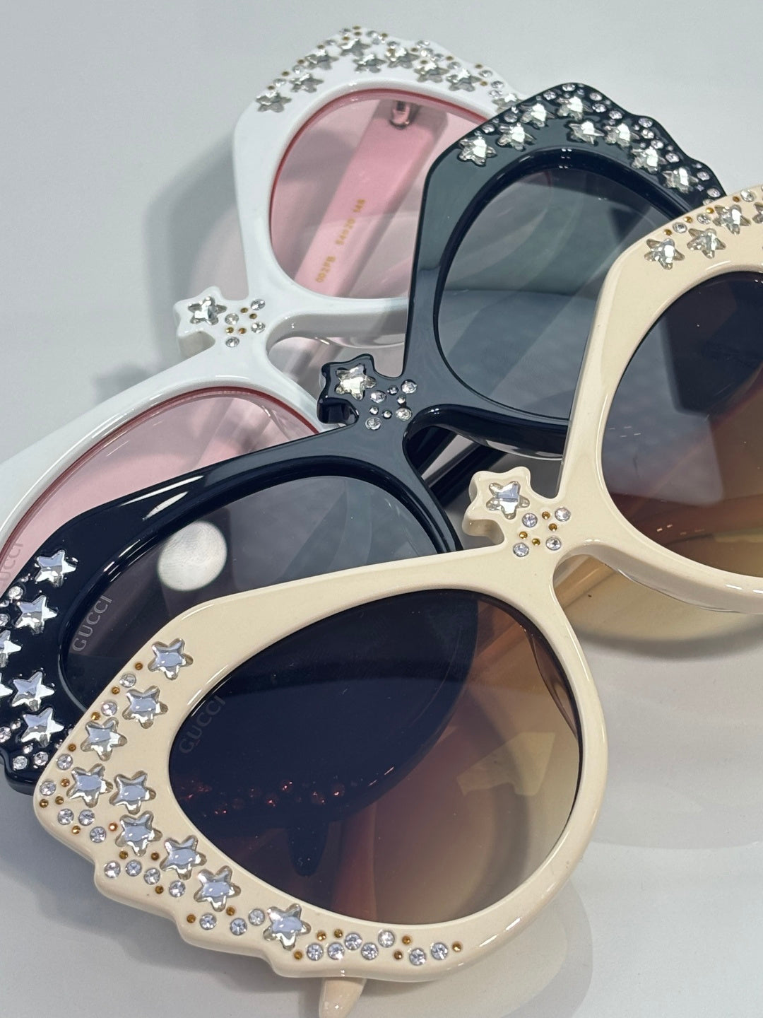 Gucci glasses with assorted cream, black, and white cat-eye frames, rhinestone stars.