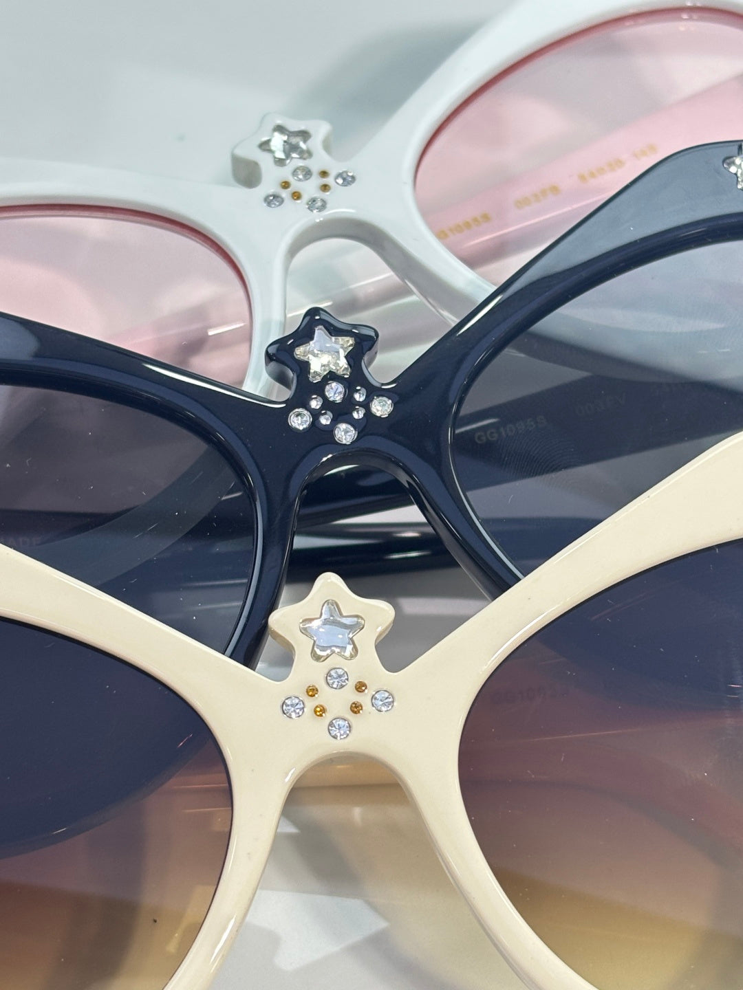 Gucci glasses with cream and navy cat-eye frames, star rhinestones, tinted lenses.