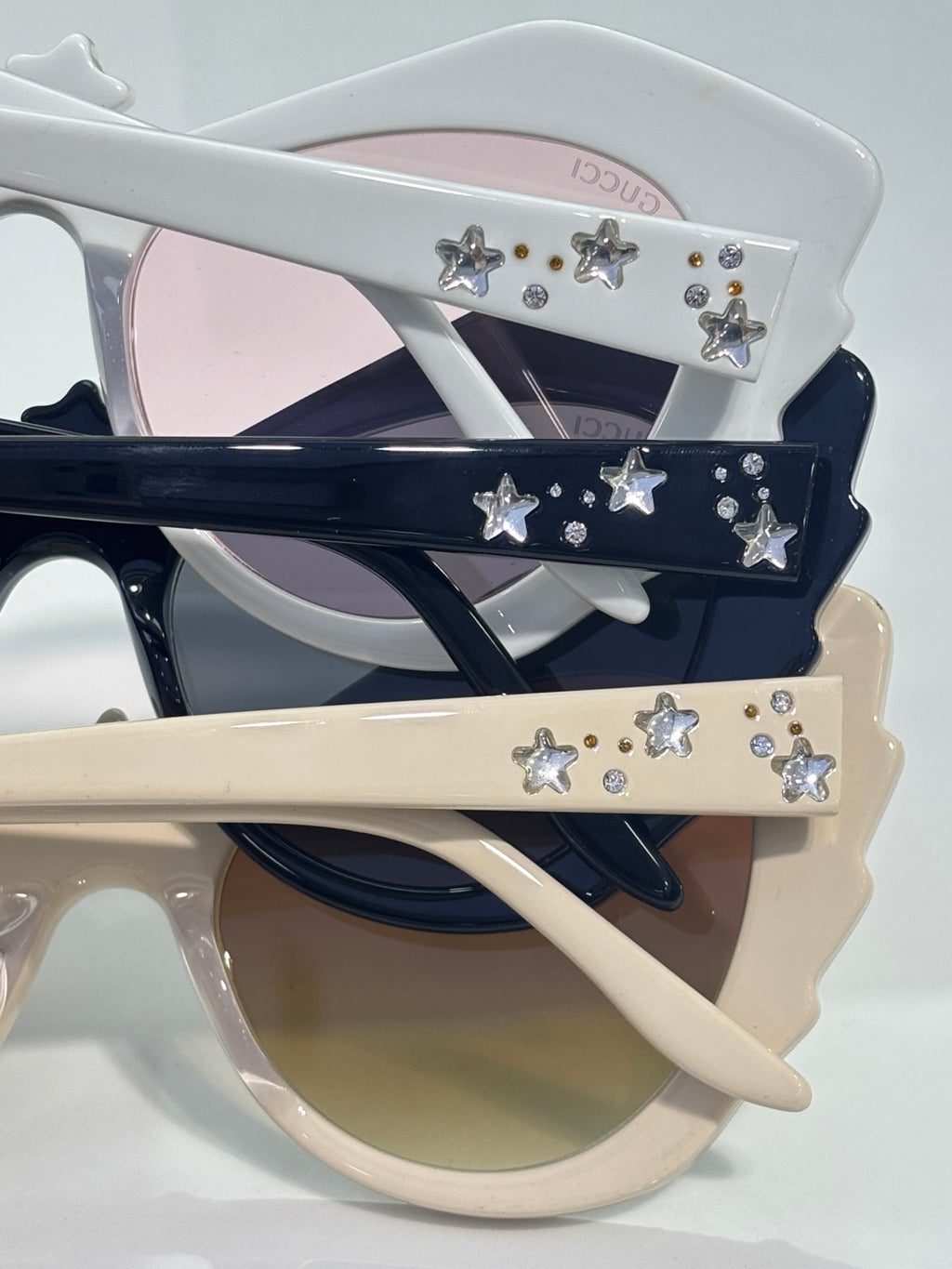 Gucci glasses set with white, navy, and cream cat-eye frames and star rhinestones.