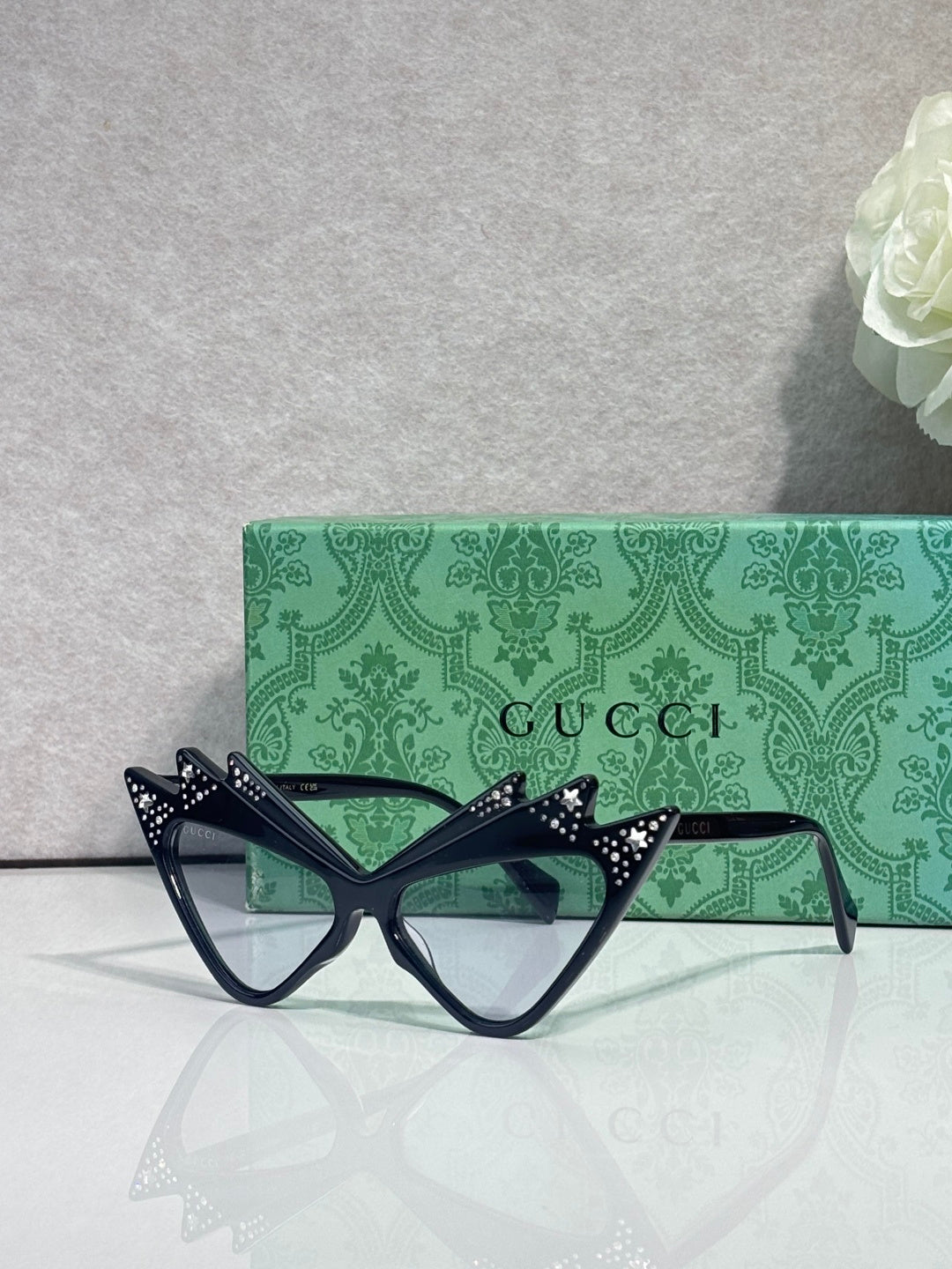 Black cat-eye sunglasses with star-studded temples and dark lenses, logo arms