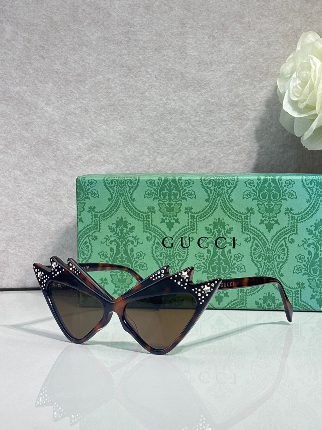 Black cat-eye sunglasses with rhinestone-studded details and dark tinted lenses