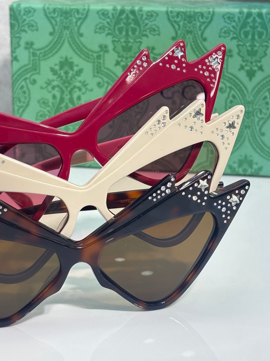 Cat-eye sunglasses in navy, cream, and burgundy with rhinestone crown details