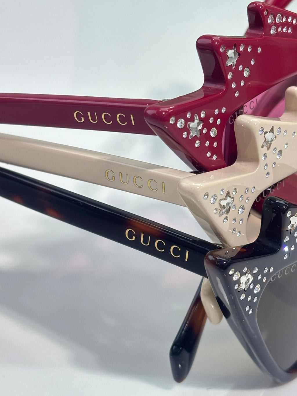 Rhinestone-studded sunglasses temple arms in burgundy, cream, and navy with logo