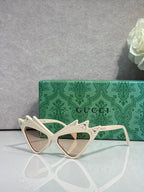 Off-white cat-eye sunglasses with rhinestone studs and tinted lenses, logo arms