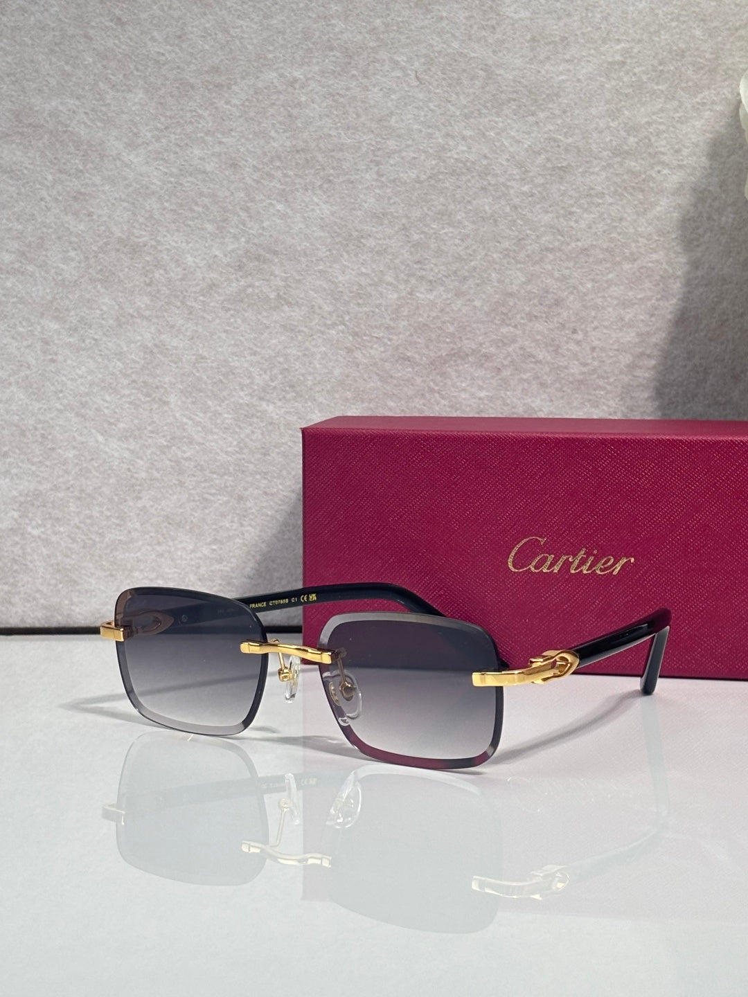 Cartier rectangular glasses with dark blue frames, gold-tone temples, tinted lenses