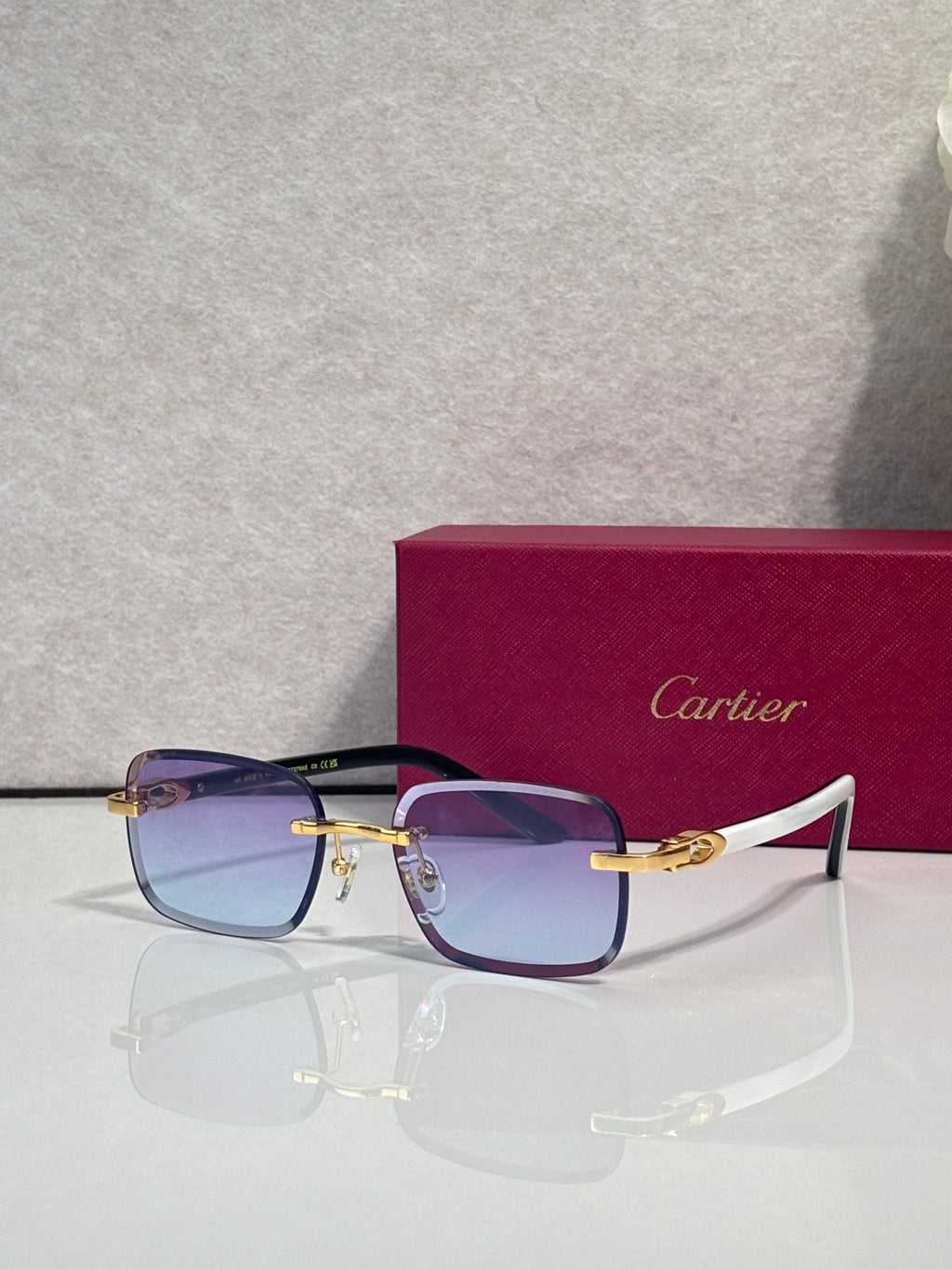 Cartier square glasses with blue frames, gold-tone temples, tinted lenses and nose pads