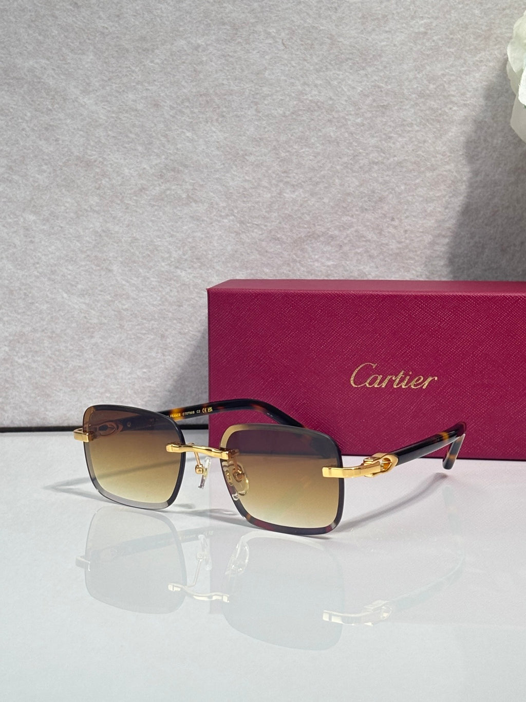 Cartier square glasses with dark frames, gold-tone hardware and temples, tinted lenses