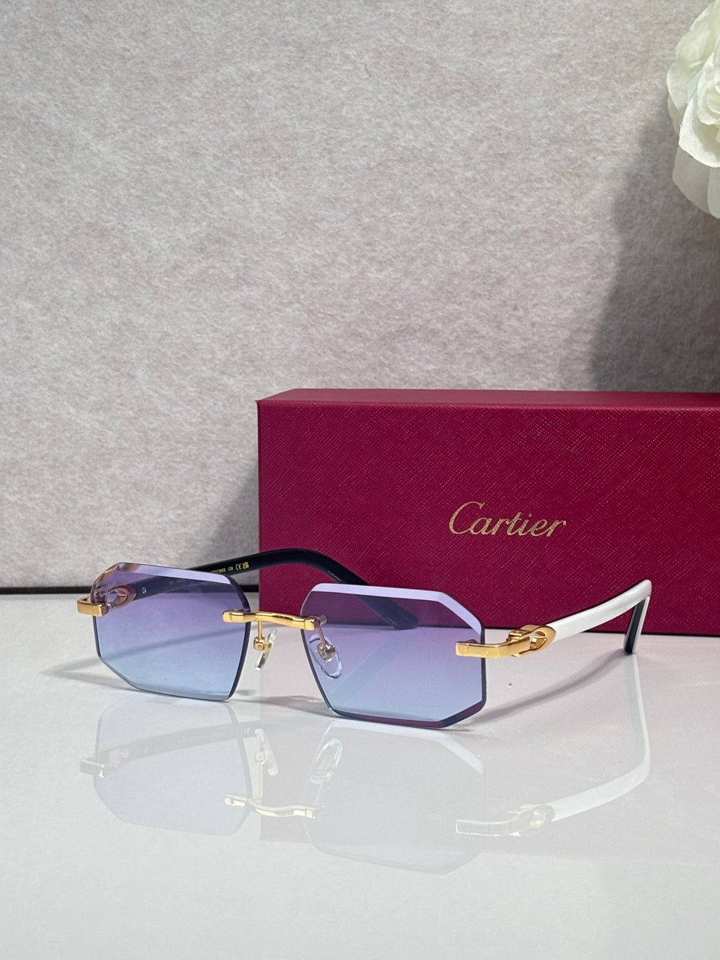 Glasses with blue-tinted lenses, gold bridge, and dark frame with rectangular shape