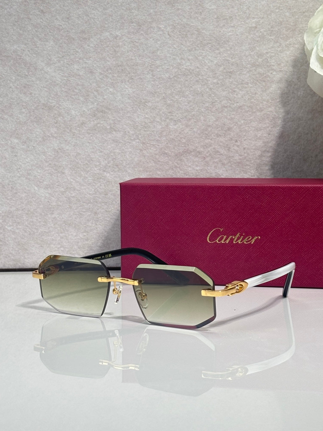 Glasses with dark frame, burgundy temples, and gold hardware with tinted lenses