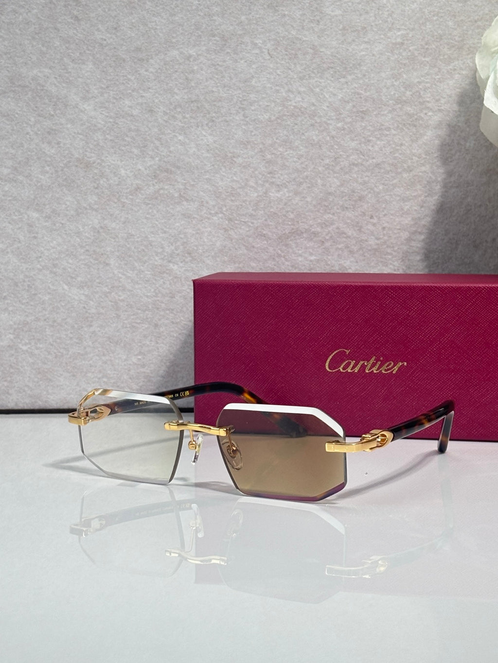 Glasses with burgundy temples, gold trim, and tinted rectangular lenses