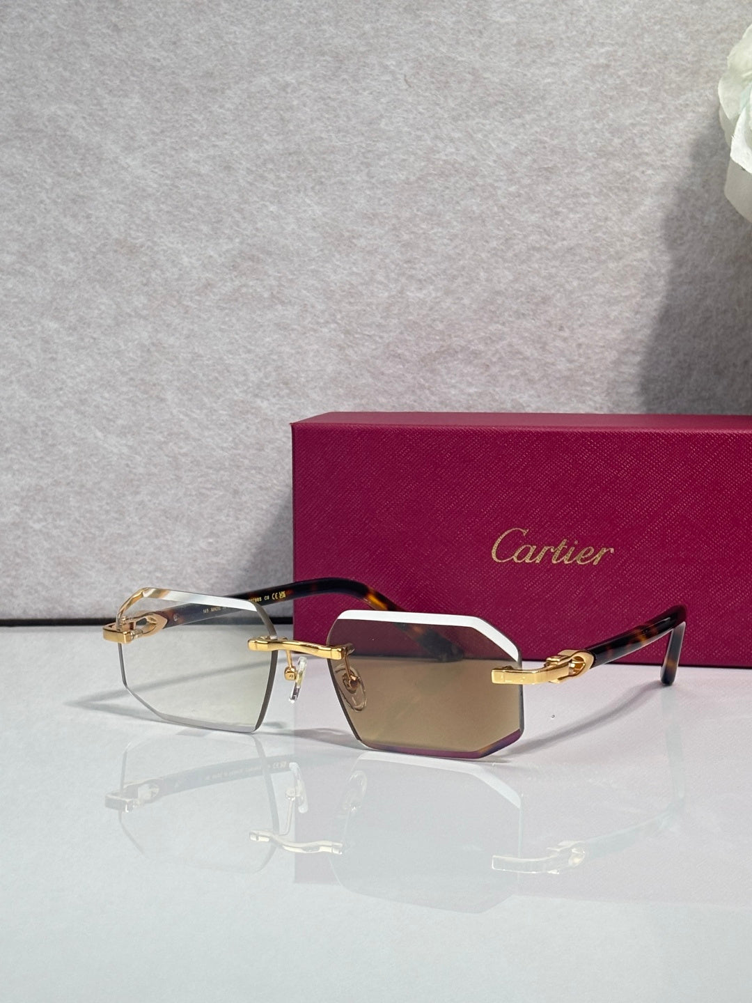 Glasses with burgundy temples, gold trim, and tinted rectangular lenses