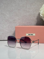 MiuMiu sunglasses, gold frames, dark purple gradient lenses with angular square shape