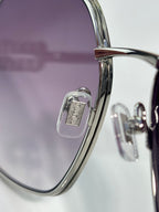 MiuMiu sunglasses close-up: gold rim and hinge with engraved logo detail