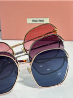 MiuMiu sunglasses pair, gold frames, pink and dark blue gradient lenses
