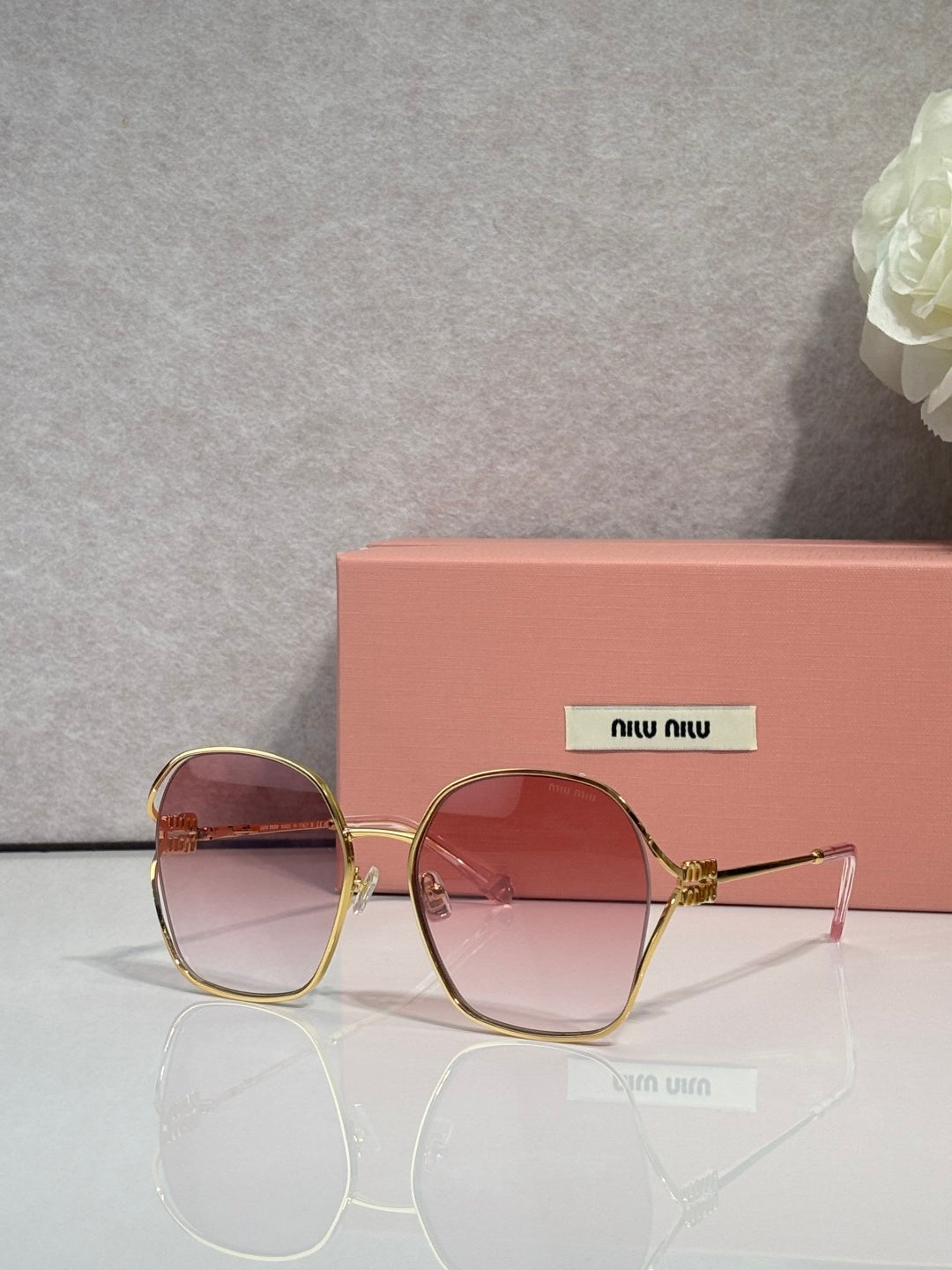 MiuMiu sunglasses, gold frames, rose-pink gradient lenses with rounded square shape
