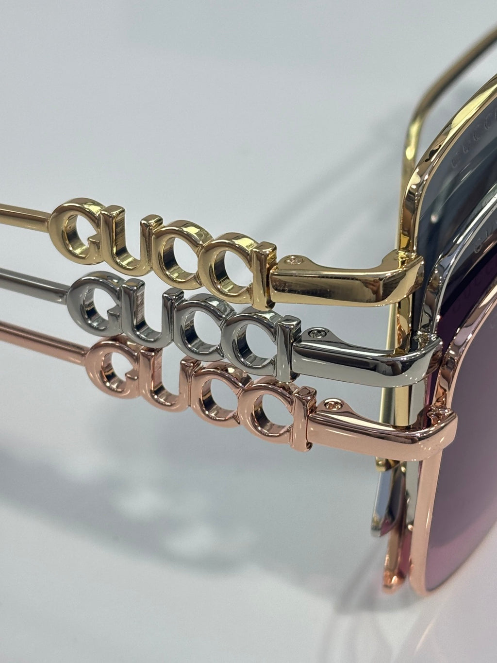 Sunglass logo bridge with gold-tone and mirrored frame accents