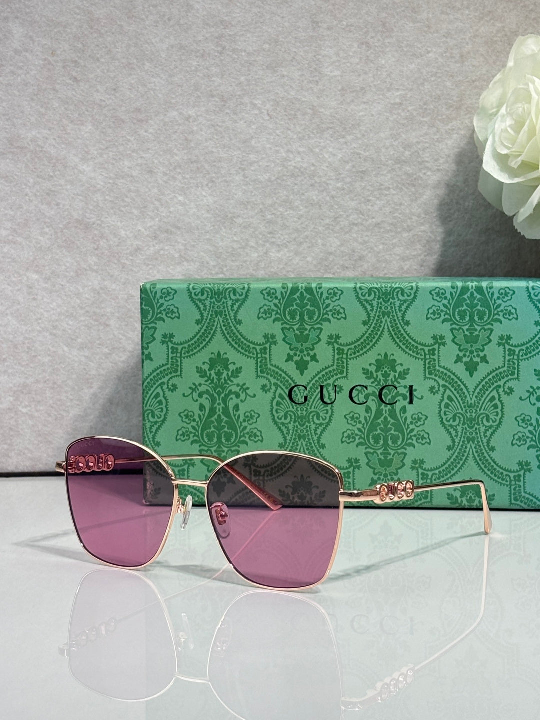 Gucci sunglasses with purple lenses and gold-tone frames