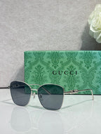 Gucci sunglasses with dark lenses and gold-tone frame