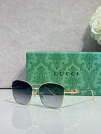 Gucci sunglasses with gold-tone frames and dark rectangular lenses