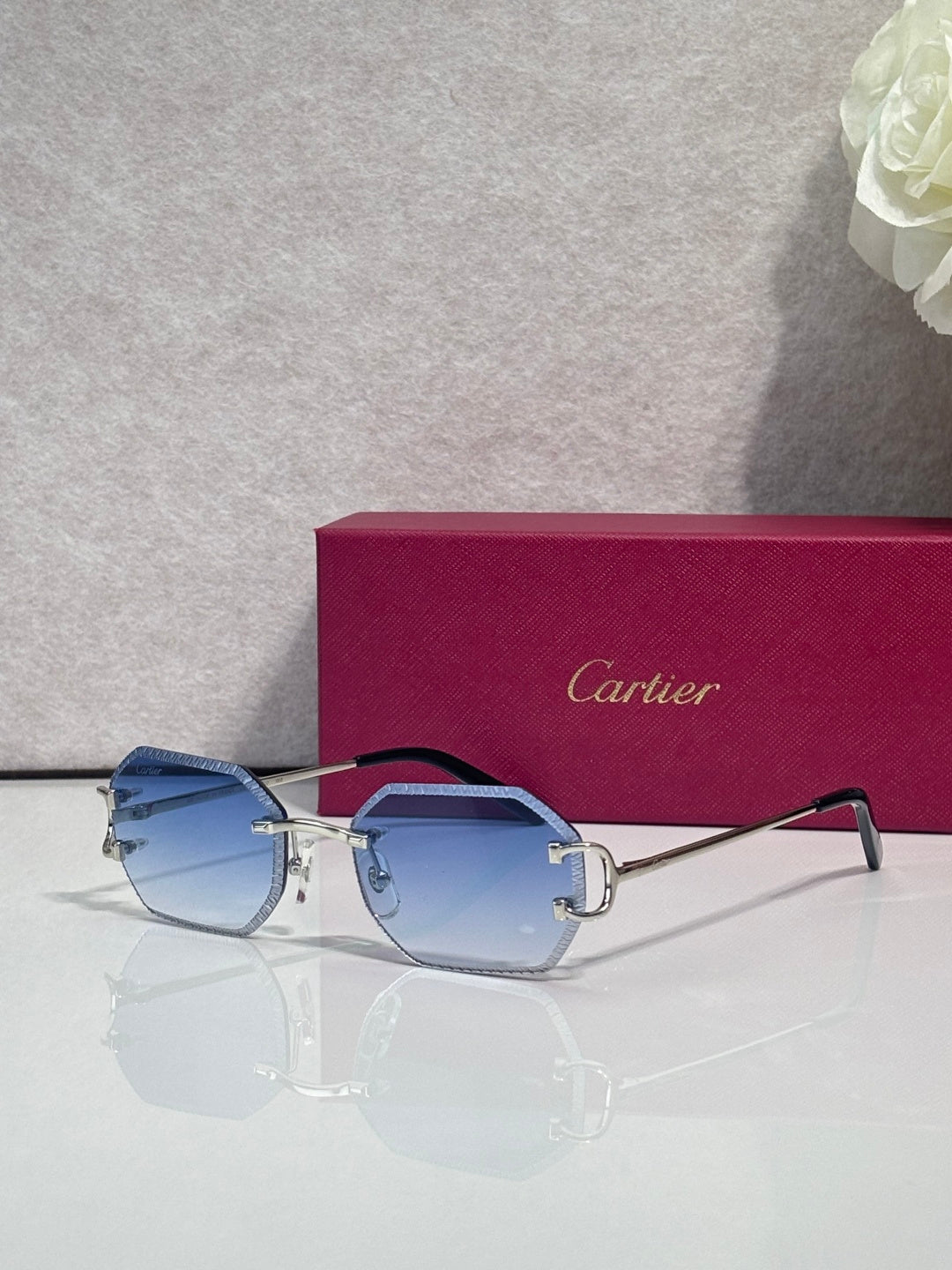 Cartier eyeglasses with silver frame and blue lenses, shield shape with logo detail