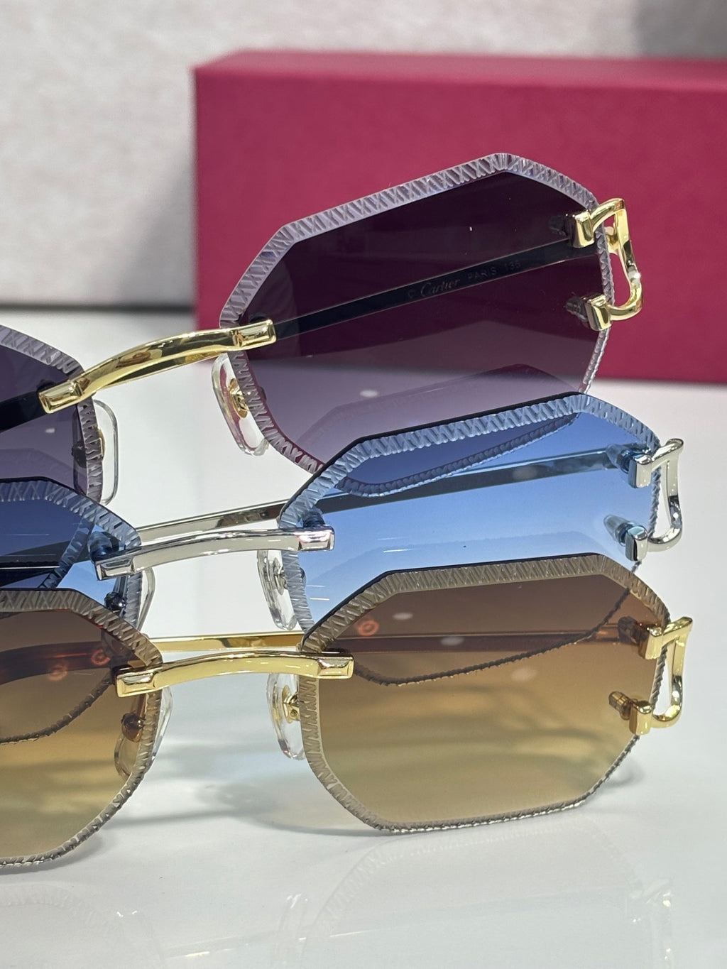 Cartier eyeglasses stacked view with gold and silver frames, blue and amber-tinted lenses