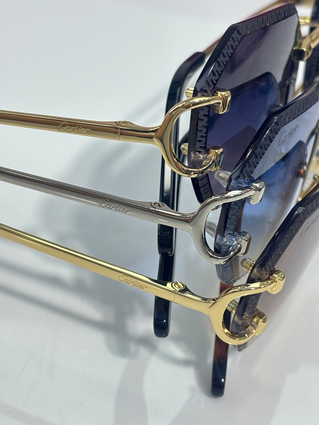 Cartier eyeglasses close-up with gold metal frame and dark blue lenses in a hinge view