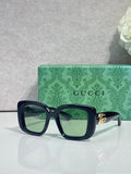 Gucci sunglasses with dark blue rounded-square frames and green-tinted lenses
