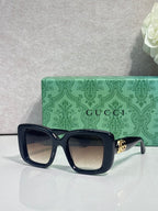 Gucci sunglasses side view with dark blue frame and gold logo hardware