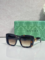 Gucci sunglasses with dark blue rounded-square frames and tinted lenses