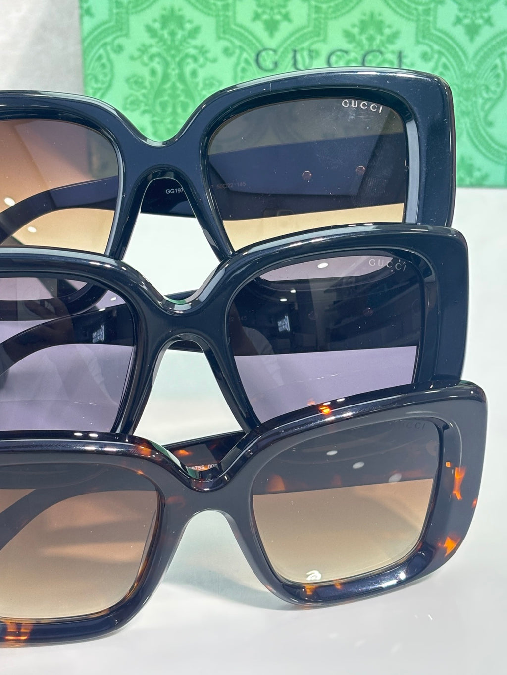 Gucci sunglasses stacked together, showing dark blue frames and tinted lenses