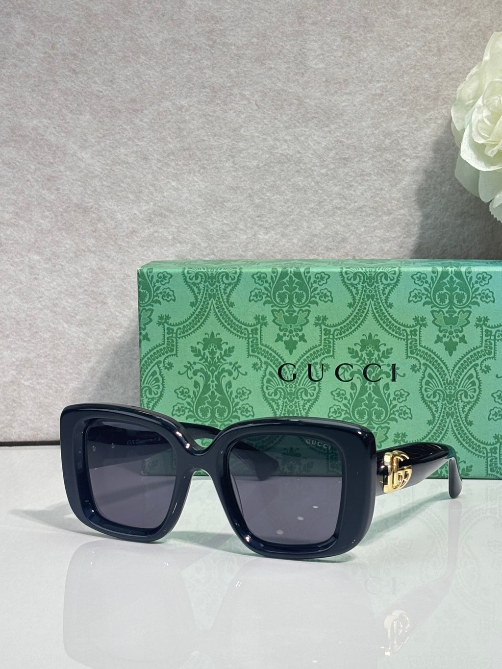 Gucci sunglasses with dark blue frames and gold logo detail on the temple