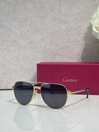 Cartier sunglasses, gold-tone metal frame with dark blue lenses, cat-eye shape