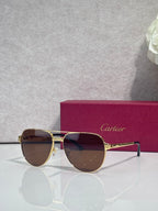 Cartier sunglasses, gold-tone frame with brown-tinted dark lenses, front view