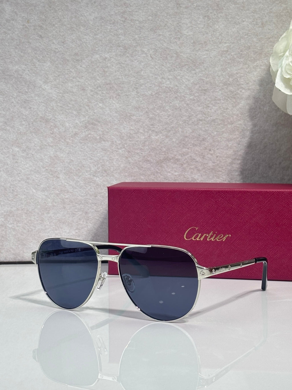 Cartier sunglasses, silver-and-gold frame with dark blue lenses, front view