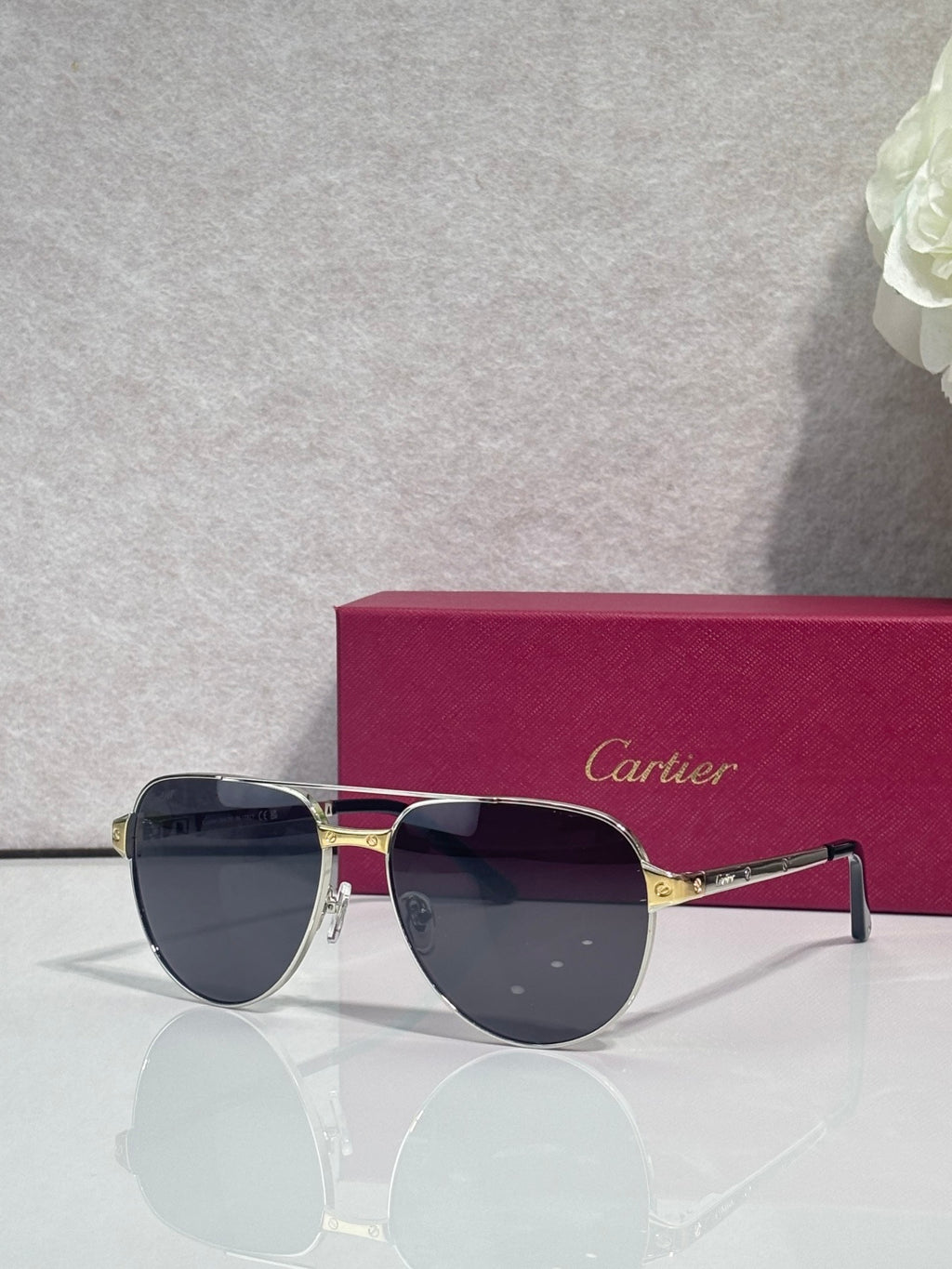 Cartier sunglasses, silver and gold frame with dark lenses, angled front view