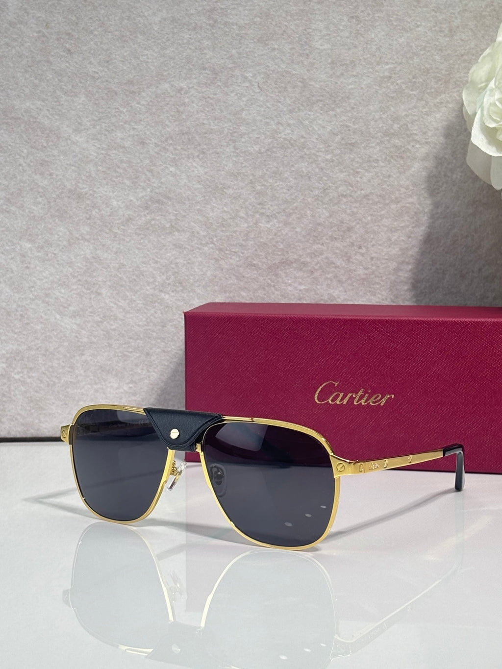 Sunglasses with gold frames and dark tinted lenses, metal bridge detail