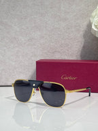 Sunglasses with gold frames and dark tinted lenses, metal bridge detail