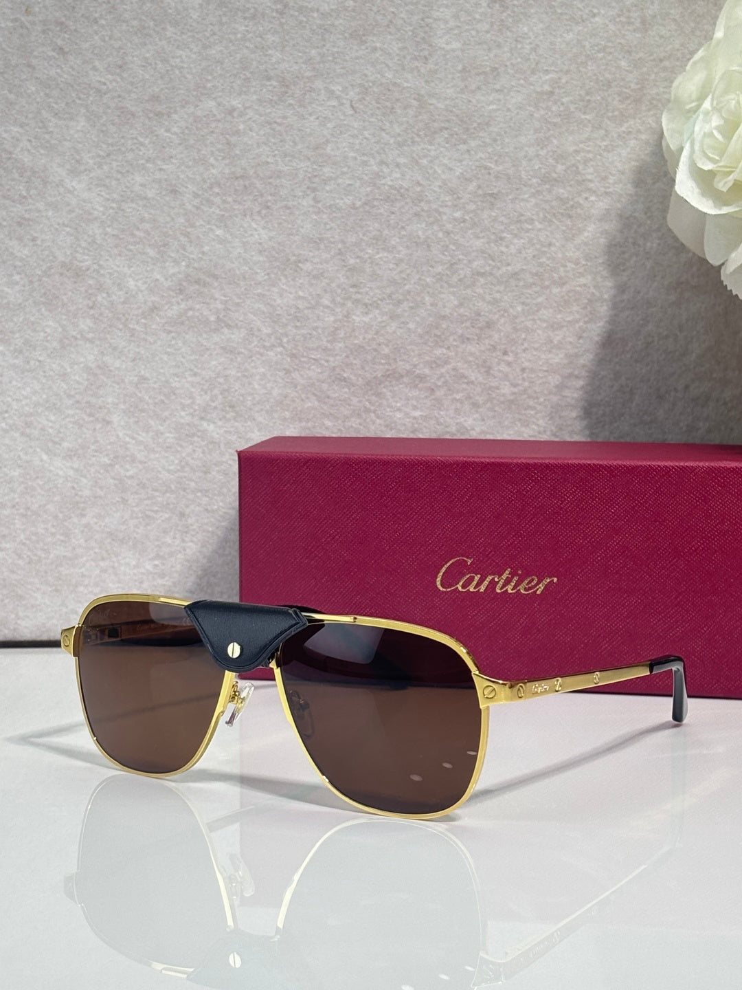 Sunglasses with gold frames and tinted lenses, sporty square silhouette